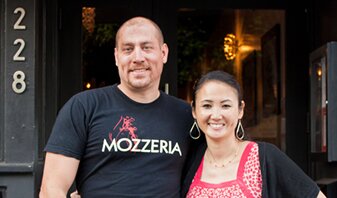 Picture of owners in front of their restaurant