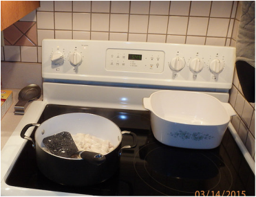 Picture of a white stovetop with a frying pan, spatula and a cooking pot