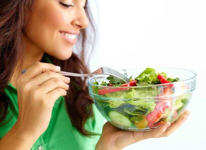 Picture of a girl eating a bowl of salad