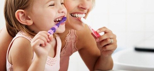 Picture of a mother and daughter brushing their teeth together
