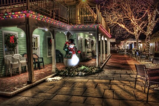 Picture of a street in Christmas lights and a decorated snowman
