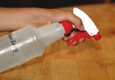 Picture of a hand holding a white spray bottle