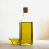 Picture of a bottle of oil and a small clear bowl of oil